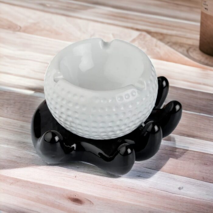 Hand Holding a Golf Ball Style Ceramic Ashtray